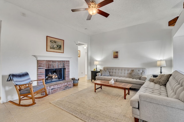 tiled living room with baseboards, a fireplace, a textured ceiling, and ceiling fan