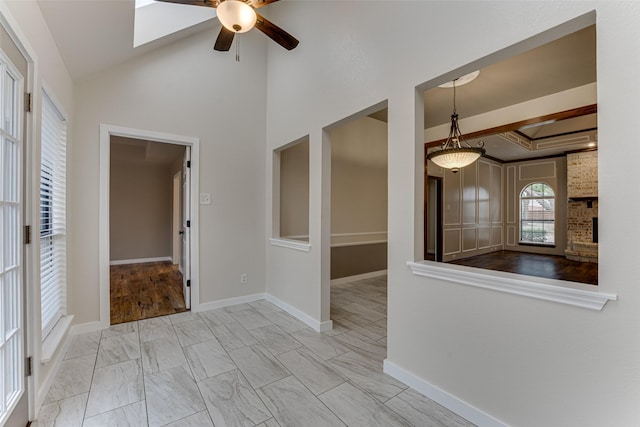 spare room with lofted ceiling, a ceiling fan, baseboards, and marble finish floor