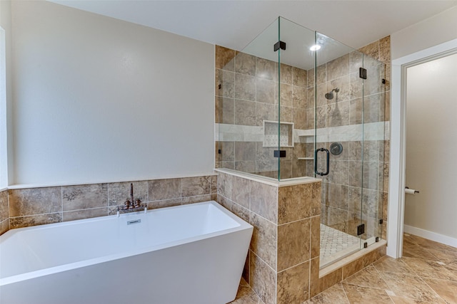 bathroom featuring a stall shower and a freestanding bath