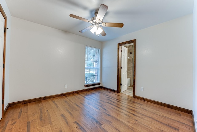 unfurnished room with baseboards, wood finished floors, and a ceiling fan