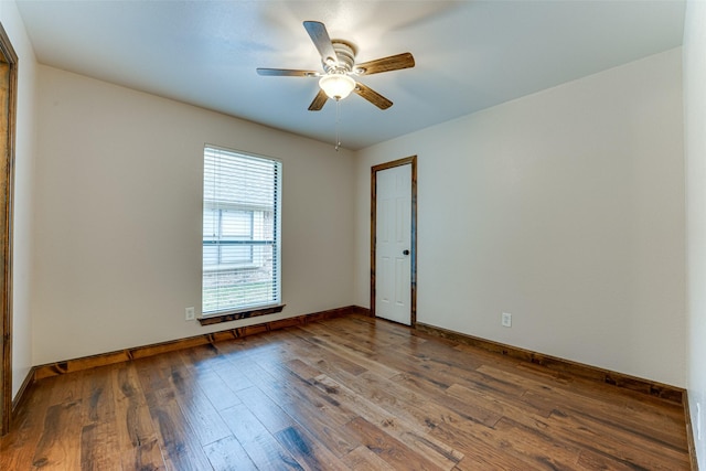 unfurnished room with a ceiling fan, wood finished floors, and baseboards