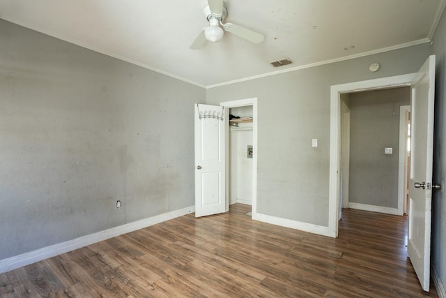 unfurnished bedroom featuring crown molding, wood finished floors, and baseboards