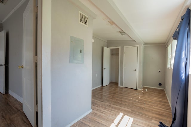 unfurnished bedroom with light wood finished floors, visible vents, two closets, baseboards, and electric panel