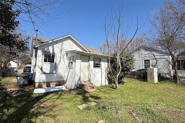 rear view of property with a lawn and a shingled roof