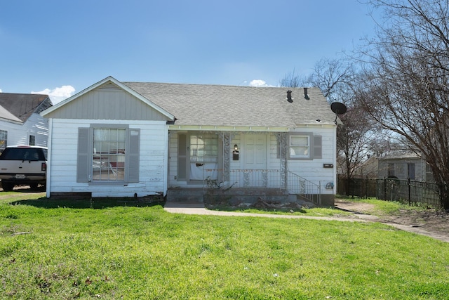 view of front of home featuring a shingled roof, a front yard, and fence