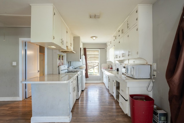 kitchen with white microwave, visible vents, light countertops, wood finished floors, and white cabinets