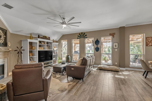 living room featuring ceiling fan, a premium fireplace, visible vents, and wood finished floors