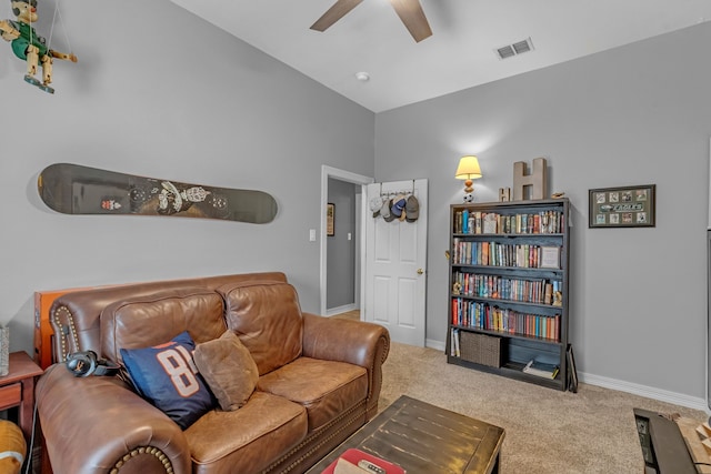 living area with visible vents, ceiling fan, baseboards, carpet, and lofted ceiling