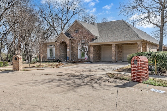 view of front facade featuring concrete driveway, an attached garage, brick siding, and roof with shingles