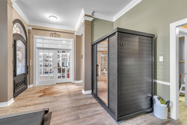 foyer entrance with french doors, baseboards, ornamental molding, and light wood finished floors