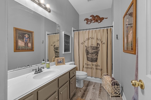 full bath featuring visible vents, toilet, vanity, and wood finished floors