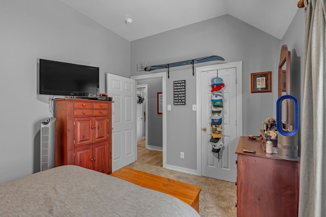 bedroom featuring light carpet, baseboards, and lofted ceiling