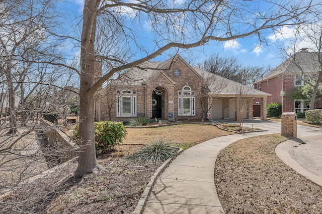 view of front of home with a garage, brick siding, roof with shingles, and driveway