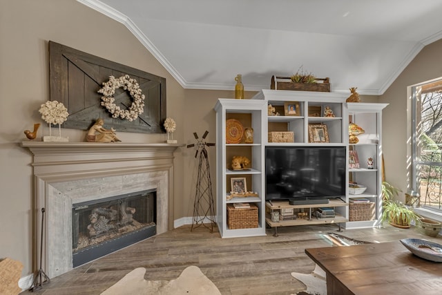 living room featuring lofted ceiling, ornamental molding, wood finished floors, a fireplace, and baseboards