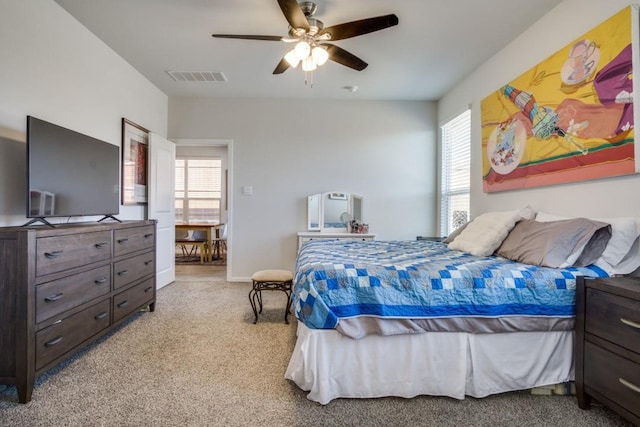 bedroom featuring visible vents, light carpet, and ceiling fan