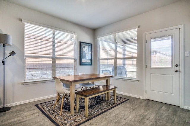 dining space featuring wood finished floors and baseboards