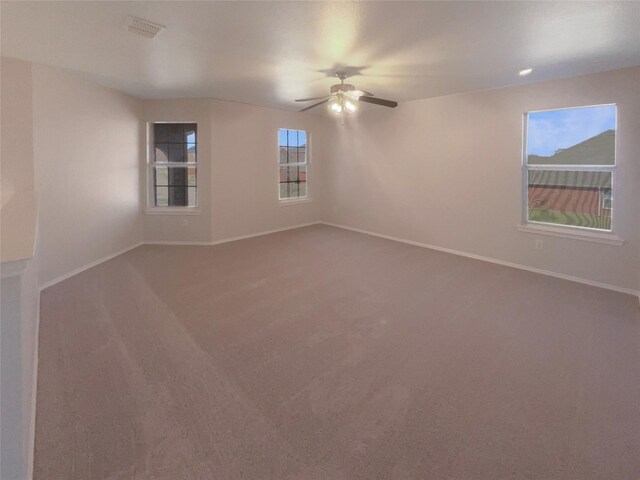 empty room featuring visible vents, baseboards, carpet, and ceiling fan