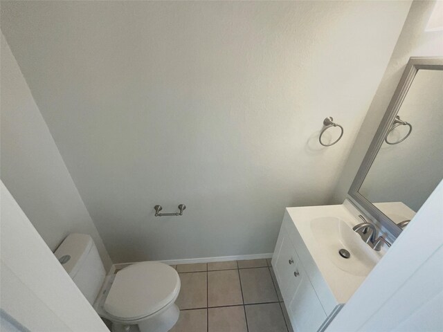 bathroom featuring vanity, tile patterned floors, toilet, and baseboards