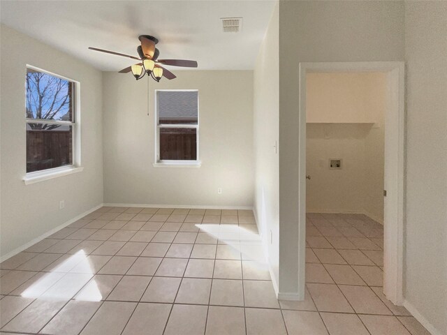 spare room with light tile patterned flooring, visible vents, baseboards, and ceiling fan