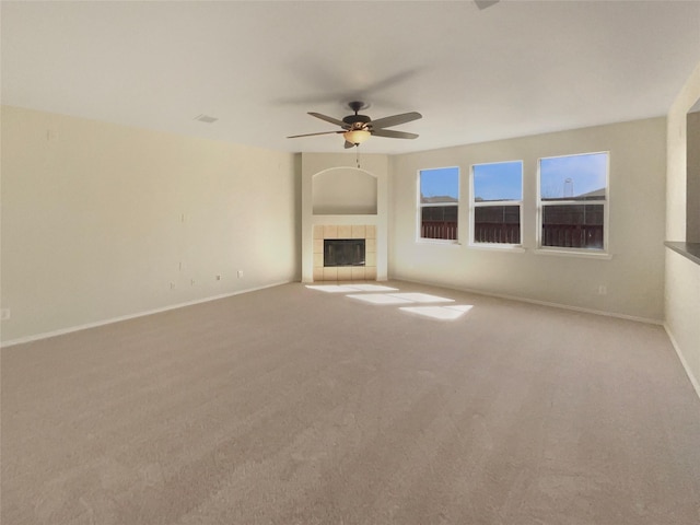 unfurnished living room with baseboards, a ceiling fan, carpet flooring, and a tile fireplace