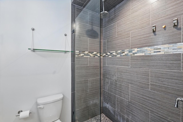 full bath with tiled shower and toilet