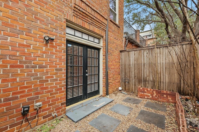 property entrance featuring brick siding and fence