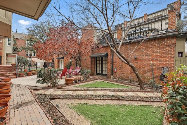 exterior space with a patio area, brick siding, and fence