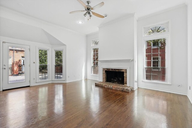 unfurnished living room with plenty of natural light, crown molding, ceiling fan, and wood finished floors