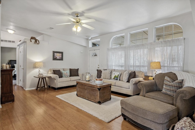 living area featuring visible vents, a ceiling fan, vaulted ceiling, and hardwood / wood-style flooring