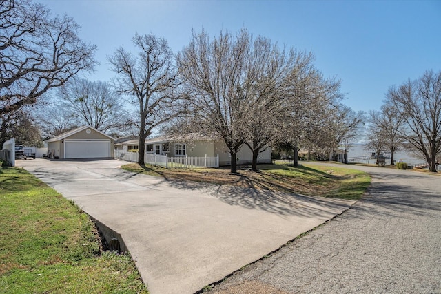 view of front facade featuring concrete driveway and a fenced front yard
