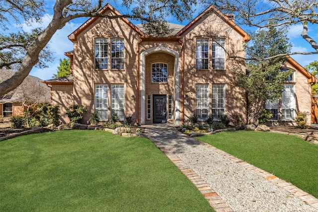 view of front of house with brick siding and a front yard