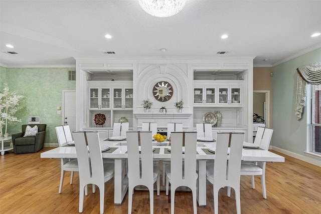 dining area with light wood-type flooring, visible vents, and ornamental molding