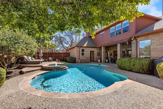 view of pool featuring a pool with connected hot tub, a patio area, and a fenced backyard