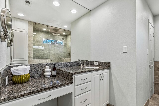 full bath with vanity, visible vents, recessed lighting, a stall shower, and a textured wall