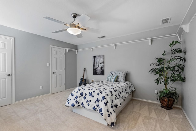 carpeted bedroom featuring a ceiling fan, visible vents, and baseboards