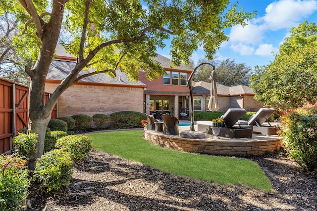 back of property with brick siding, a patio area, roof with shingles, and fence