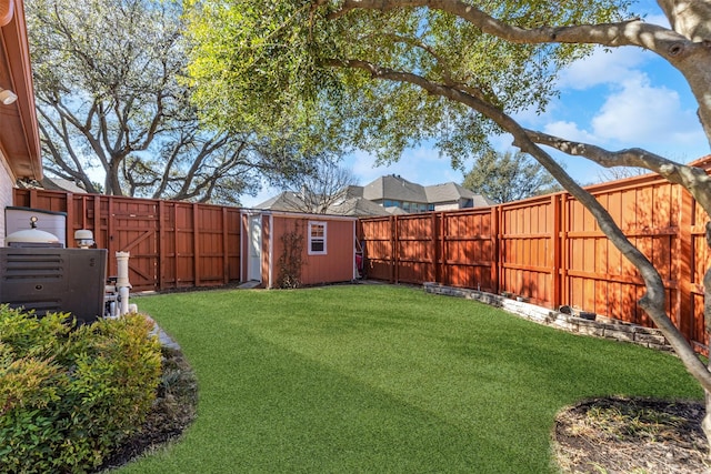 view of yard with an outbuilding, a fenced backyard, and a storage shed