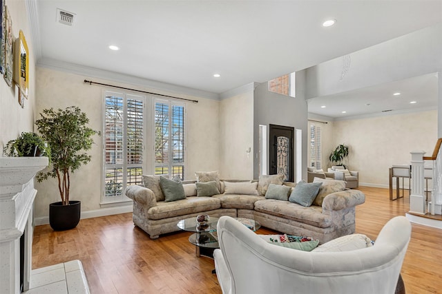 living room with crown molding, wood finished floors, and visible vents