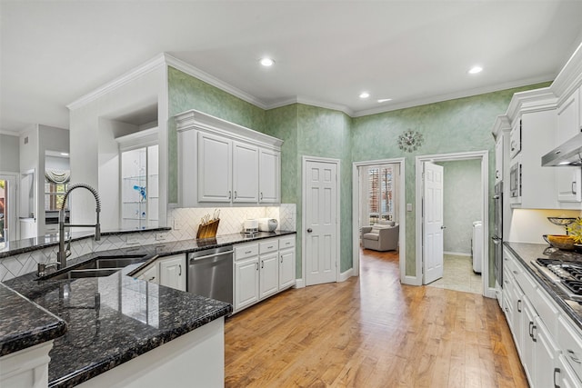 kitchen with ornamental molding, light wood-style flooring, a sink, stainless steel appliances, and white cabinets