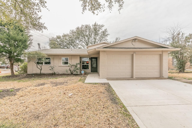 ranch-style house featuring concrete driveway, an attached garage, and brick siding