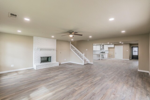 unfurnished living room with recessed lighting, light wood-style flooring, a fireplace, and a ceiling fan