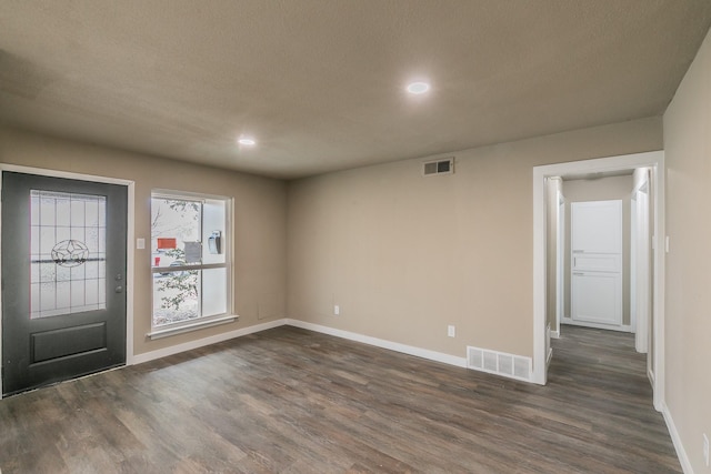 entryway featuring dark wood finished floors, baseboards, and visible vents