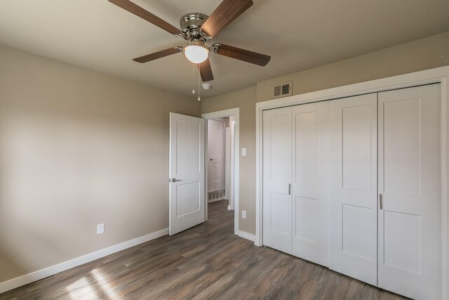 unfurnished bedroom featuring visible vents, baseboards, a closet, and wood finished floors