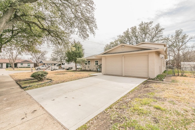 view of front of home with brick siding, driveway, an attached garage, and fence