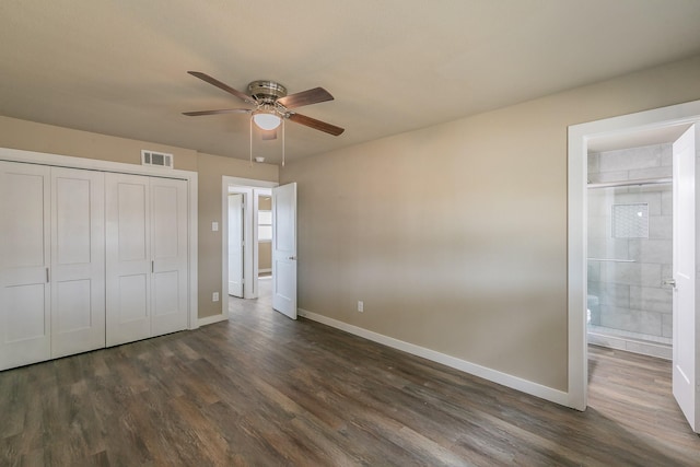 unfurnished bedroom with dark wood-style floors, visible vents, a closet, and baseboards