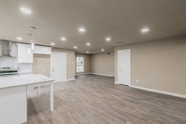 kitchen with light wood-type flooring, electric range, tasteful backsplash, wall chimney exhaust hood, and white cabinets