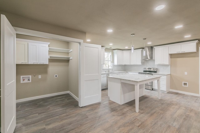 kitchen with white dishwasher, decorative backsplash, electric stove, wall chimney range hood, and a center island