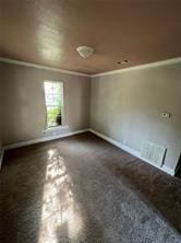 empty room featuring crown molding and baseboards