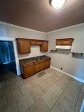 kitchen with dark countertops, brown cabinets, and baseboards