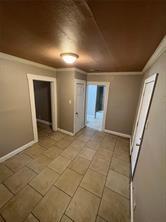 interior space with baseboards and ornamental molding